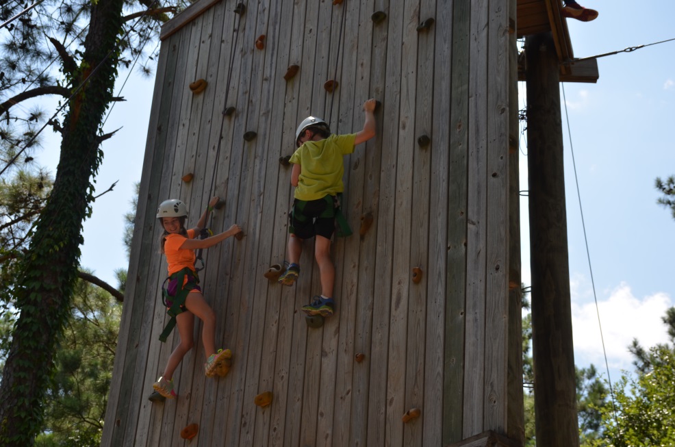 Two campers climbing up the wall.